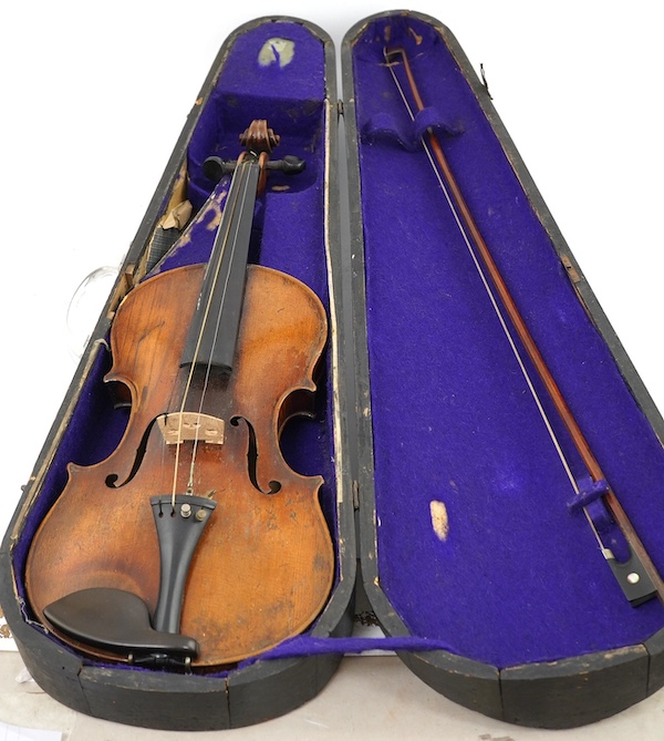 A late 19th century German Nuremberg school violin c.1880, Stradivarius pattern with a finely carved scroll and a large 14.25 inch body, together with a fully mounted German octagonal bow, contained within a contemporary